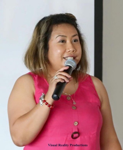 Norita speaking into a handheld microphone at the HAA 2015 celebration.