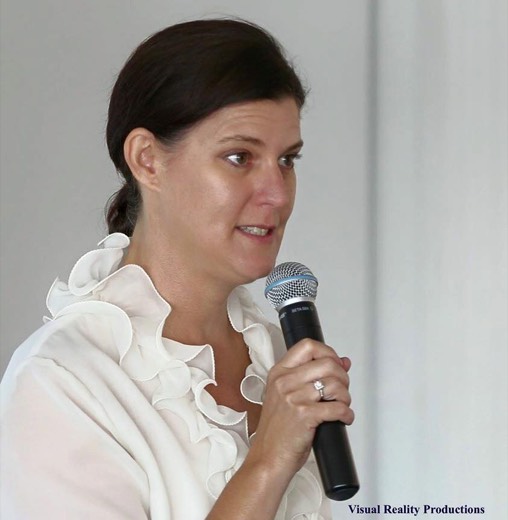 Fleur Allen speaking into a handheld microphone at the HAA 2015 celebration.
