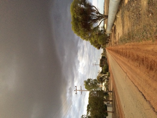 The water pipeline running beside a road under a darkening sky