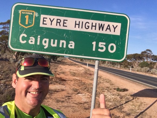 Retrospective Day 26 photo of Gary beside an Eyre Highway sign for Caiguna.