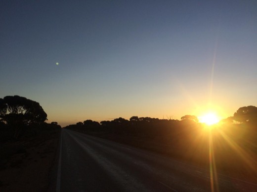 Evening sun over the long straight road at the end of Day 27.
