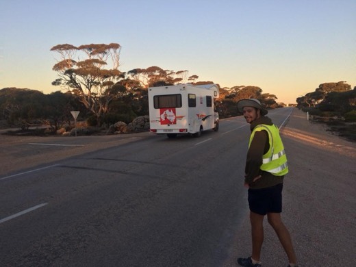 Ols in hi-vis walking beside the support campervan