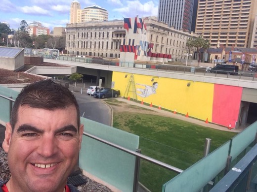 Gary taking a selfie with Yvonne's mural-in-progress in Adelaide.