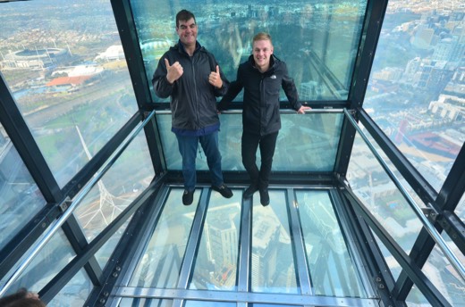 Gary and Ben standing in The Edge glass box at Eureka Skydeck above Melbourne