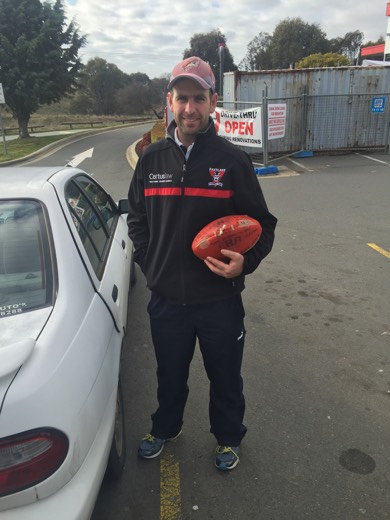 Matt Napier holding the football he used on his own Perth to Sydney walk.