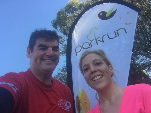 Gary with Helen beside the St Peters parkrun flag.