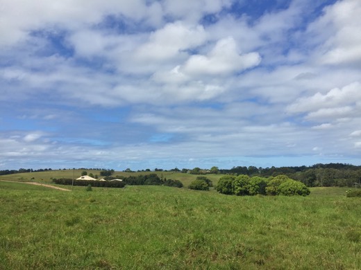 The coast visible beyond green hills on the approach to Byron Bay.