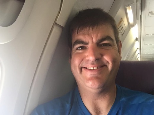 Gary smiling in his seat on the flight home from Brisbane to Perth.