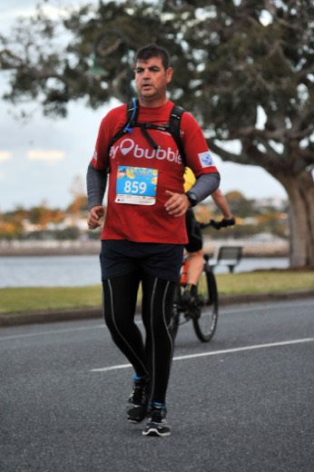 Gary running the Twilight Bay Run half marathon in his red HAA shirt.