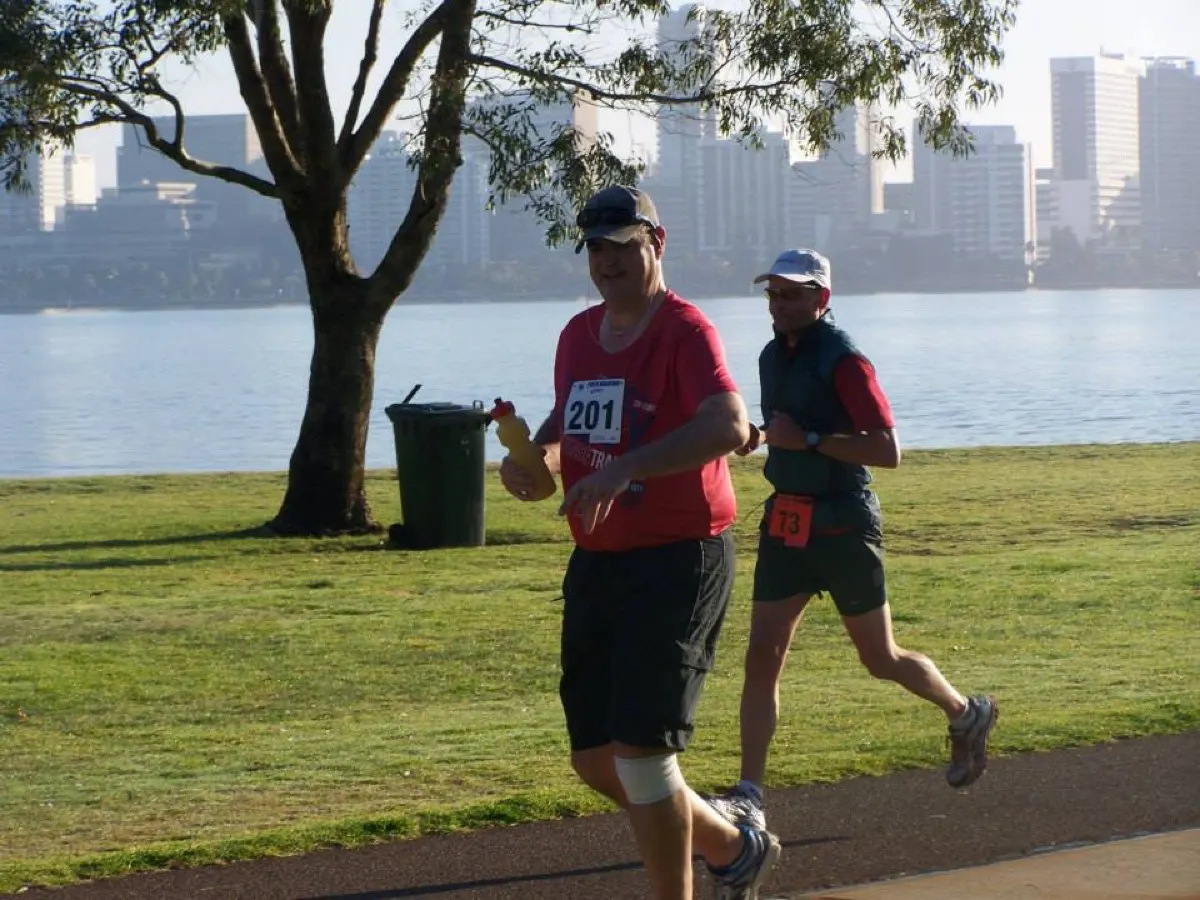 Gary running during the 2013 Perth Marathon with the Swan River and Perth city behind him