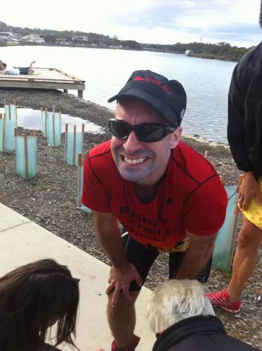 Graham Whittaker smiling by the water after completing a 100 kilometre run