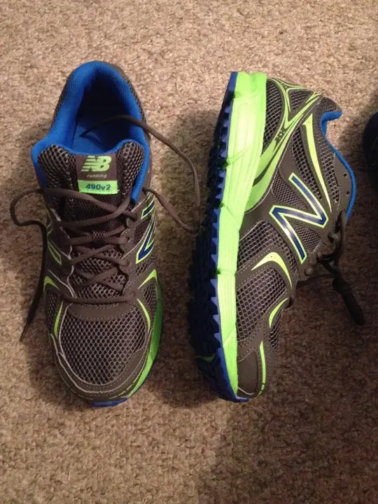 A pair of New Balance trail running shoes on carpet