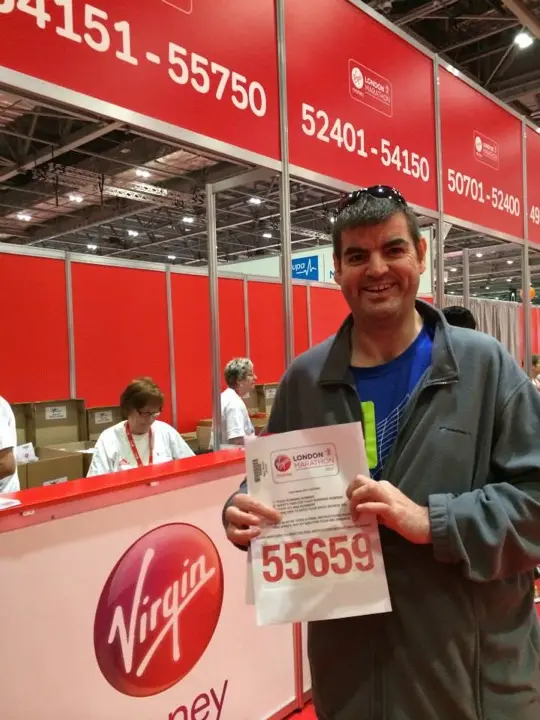 Gary holding his London Marathon race number at the expo registration desks