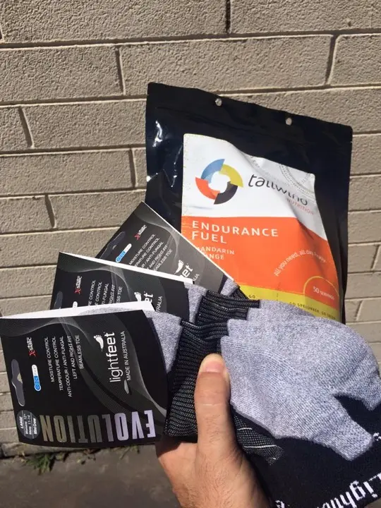 Tailwind endurance fuel and Lightfeet socks held in one hand